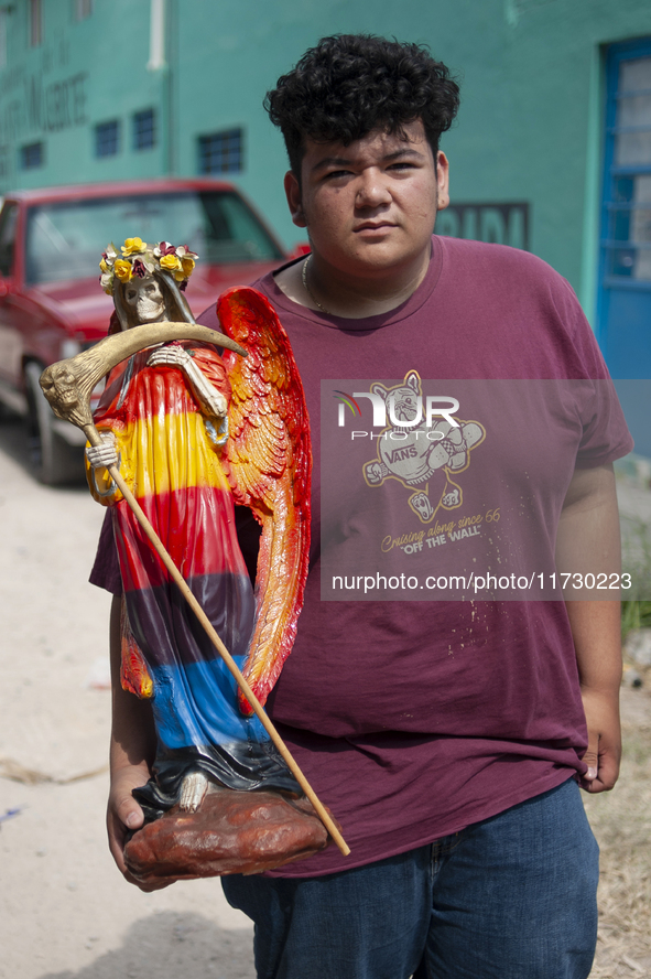 A faithful carries a Santa Muerte image to bless it at the temple of Santa Muerte in the municipality of Pedro Escobedo, Mexico, on November...