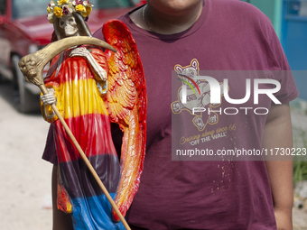 A faithful carries a Santa Muerte image to bless it at the temple of Santa Muerte in the municipality of Pedro Escobedo, Mexico, on November...