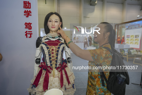 A spectator touches a silicone material to simulate the face of an embodied robot in Xiamen, China, on November 1, 2024. 