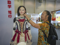 A spectator touches a silicone material to simulate the face of an embodied robot in Xiamen, China, on November 1, 2024. (