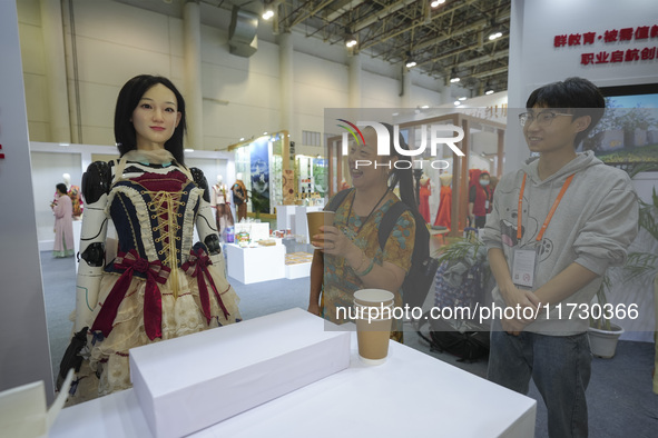 An audience speaks with an embodied robot in Xiamen, China, on November 1, 2024. 