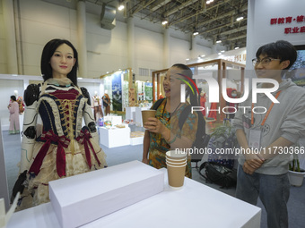 An audience speaks with an embodied robot in Xiamen, China, on November 1, 2024. (