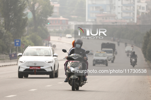 Nepalese people use face masks to protect themselves from air pollution on the roads of Kathmandu Valley in Kathmandu Valley, Nepal, on Nove...