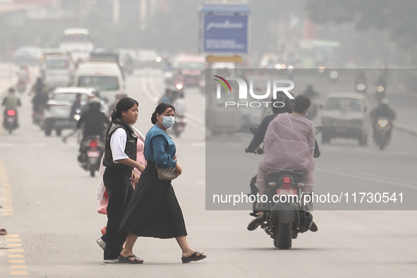 Nepalese people use face masks to protect themselves from air pollution on the roads of Kathmandu Valley in Kathmandu Valley, Nepal, on Nove...