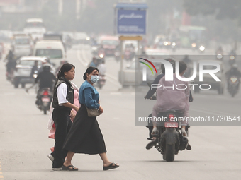 Nepalese people use face masks to protect themselves from air pollution on the roads of Kathmandu Valley in Kathmandu Valley, Nepal, on Nove...