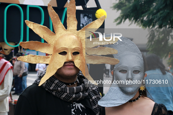 A couple wearing Sun and Moon masks is seen during the Twenty-seventh Edition of the University Day of the Dead Festival ''Mega Ofrenda UNAM...