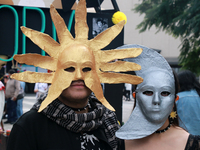 A couple wearing Sun and Moon masks is seen during the Twenty-seventh Edition of the University Day of the Dead Festival ''Mega Ofrenda UNAM...