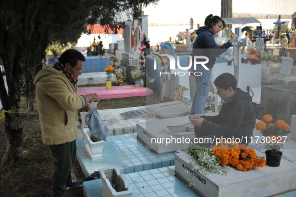 Relatives decorate the graves of their loved ones with cempasuchil flowers and hold a vigil at the Municipal Cemetery of Amealco de Bonfil....