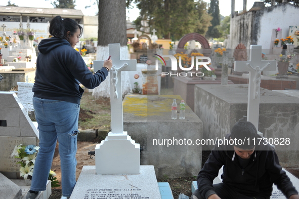 Relatives decorate the graves of their loved ones with cempasuchil flowers and hold a vigil at the Municipal Cemetery of Amealco de Bonfil....