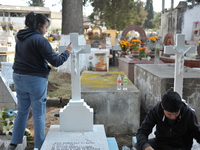 Relatives decorate the graves of their loved ones with cempasuchil flowers and hold a vigil at the Municipal Cemetery of Amealco de Bonfil....