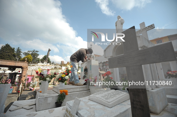 A person decorates the graves of his loved ones with cempasuchil flowers and holds a vigil at the Municipal Cemetery of Amealco de Bonfil. A...