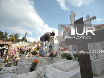 A person decorates the graves of his loved ones with cempasuchil flowers and holds a vigil at the Municipal Cemetery of Amealco de Bonfil. A...