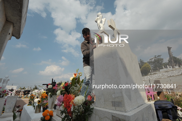 A person decorates the graves of his loved ones with cempasuchil flowers and holds a vigil at the Municipal Cemetery of Amealco de Bonfil. A...