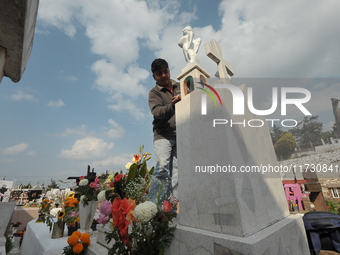 A person decorates the graves of his loved ones with cempasuchil flowers and holds a vigil at the Municipal Cemetery of Amealco de Bonfil. A...