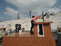 A person decorates the graves of her loved ones with cempasuchil flowers and holds a vigil at the Municipal Cemetery of Amealco de Bonfil. A...