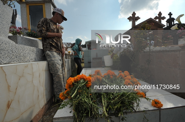 Relatives decorate the graves of their loved ones with cempasuchil flowers and hold a vigil at the Municipal Cemetery of Amealco de Bonfil....