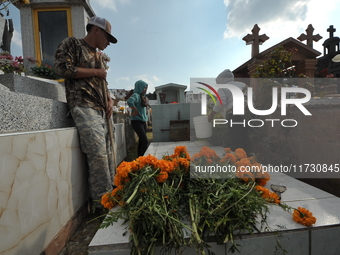 Relatives decorate the graves of their loved ones with cempasuchil flowers and hold a vigil at the Municipal Cemetery of Amealco de Bonfil....