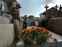 Relatives decorate the graves of their loved ones with cempasuchil flowers and hold a vigil at the Municipal Cemetery of Amealco de Bonfil....