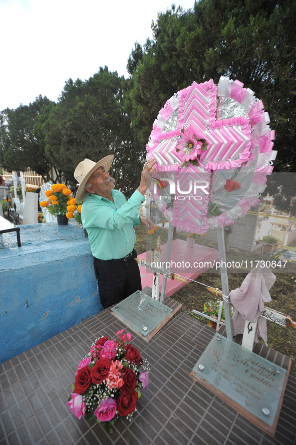 A person decorates the graves of his loved ones with cempasuchil flowers and holds a vigil at the Municipal Cemetery of Amealco de Bonfil. A...