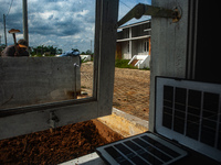 A worker, Wahyu, 31, repairs a water installation with the foreground of an emergency solar power plant at a house in the new subsidized set...