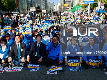 Democratic Party leader Lee Jae-myung (center), along with opposition lawmakers and tens of thousands of party members, holds a rally speech...