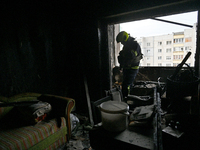 A rescuer is in an apartment in a 16-storey residential building in the Sviatoshynskyi district damaged by a fire caused by falling Russian...