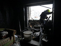 A rescuer is in an apartment in a 16-storey residential building in the Sviatoshynskyi district damaged by a fire caused by falling Russian...