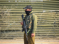 An Indian policeman stands guard near the site of a gunbattle between suspected militants and security forces in Srinagar, Jammu and Kashmir...