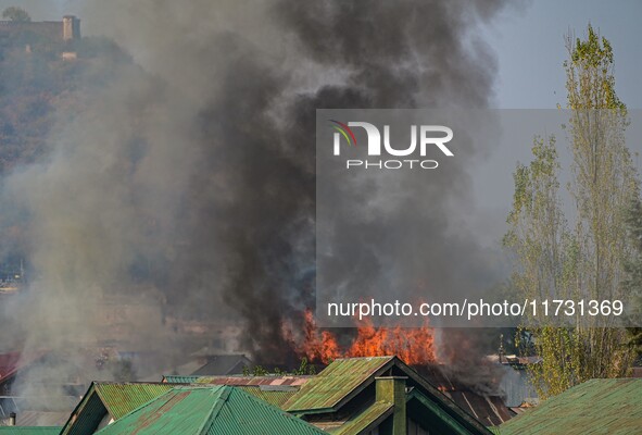 Flames and smoke billow from a residential building where militants are suspected to take refuge during a gun battle between suspected milit...