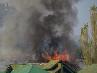 Flames and smoke billow from a residential building where militants are suspected to take refuge during a gun battle between suspected milit...