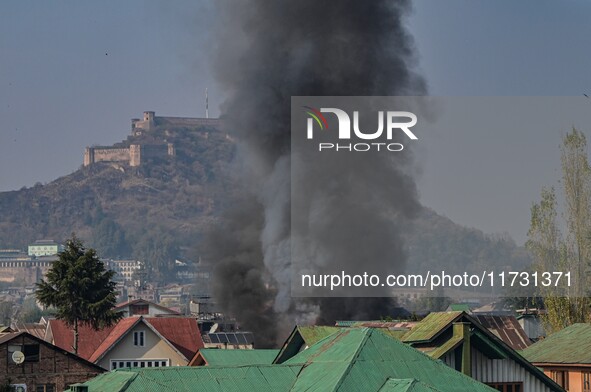 Flames and smoke billow from a residential building where militants are suspected to take refuge during a gun battle between suspected milit...