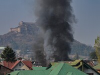 Flames and smoke billow from a residential building where militants are suspected to take refuge during a gun battle between suspected milit...