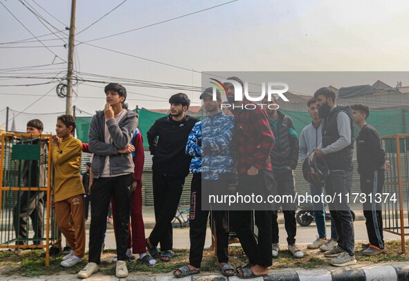 Civilians look towards the site of a gun battle between suspected militants and security forces in Srinagar, Jammu and Kashmir, on November...