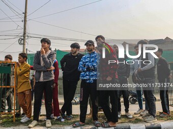 Civilians look towards the site of a gun battle between suspected militants and security forces in Srinagar, Jammu and Kashmir, on November...