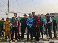 Civilians look towards the site of a gun battle between suspected militants and security forces in Srinagar, Jammu and Kashmir, on November...