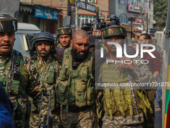 An injured Indian security personnel is helped by his colleague near the site of a gunbattle between suspected militants and security forces...