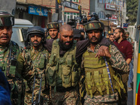 An injured Indian security personnel is helped by his colleague near the site of a gunbattle between suspected militants and security forces...