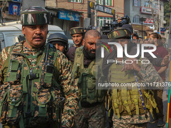 An injured Indian security personnel is helped by his colleague near the site of a gunbattle between suspected militants and security forces...