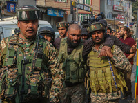 An injured Indian security personnel is helped by his colleague near the site of a gunbattle between suspected militants and security forces...