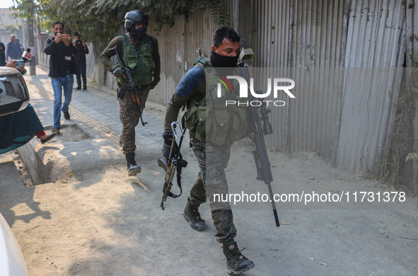 An Indian security personnel carries a sniper gun near the site of a gunbattle between suspected militants and security forces in Srinagar,...