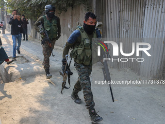 An Indian security personnel carries a sniper gun near the site of a gunbattle between suspected militants and security forces in Srinagar,...