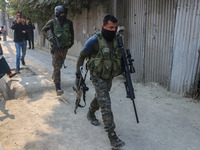 An Indian security personnel carries a sniper gun near the site of a gunbattle between suspected militants and security forces in Srinagar,...