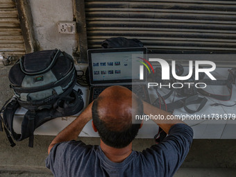 A photojournalist works near the site of a gun battle between suspected militants and security forces in Srinagar, Jammu and Kashmir, on Nov...