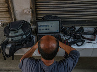 A photojournalist works near the site of a gun battle between suspected militants and security forces in Srinagar, Jammu and Kashmir, on Nov...