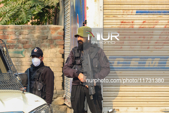 An Indian security personnel stands guard near the site of a gunbattle between suspected militants and security forces in Srinagar, Jammu an...