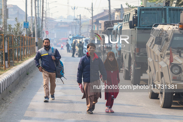 Civilians walk near the site of a gun battle between suspected militants and security forces in Srinagar, Jammu and Kashmir, on November 2,...