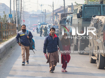 Civilians walk near the site of a gun battle between suspected militants and security forces in Srinagar, Jammu and Kashmir, on November 2,...