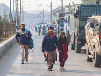 Civilians walk near the site of a gun battle between suspected militants and security forces in Srinagar, Jammu and Kashmir, on November 2,...