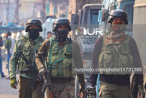 Indian security personnel walk near the site of a gunbattle between suspected militants and security forces in Srinagar, Jammu and Kashmir,...