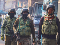 Indian security personnel walk near the site of a gunbattle between suspected militants and security forces in Srinagar, Jammu and Kashmir,...